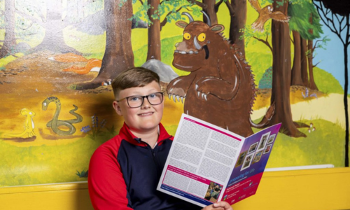 Boy with glasses reading a magazine